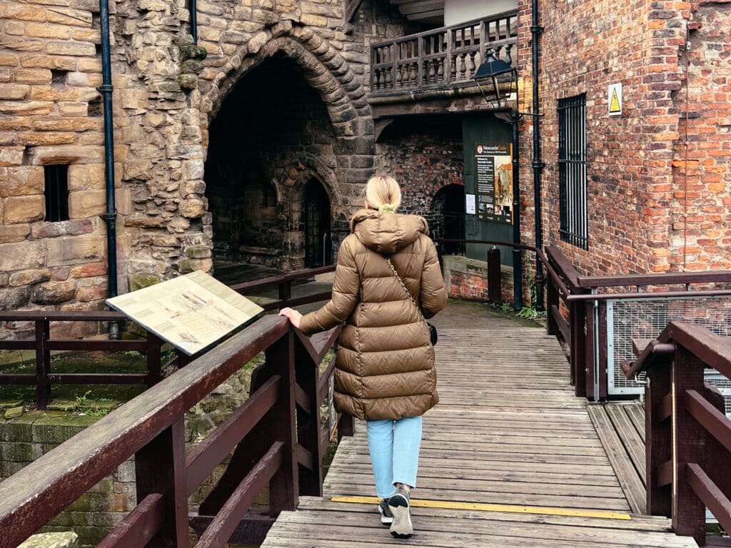 Besucherin auf dem Holzsteg am The Black Gate des Newcastle Castle in Newcastle upon Tyne